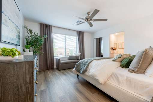 A bedroom with a large bed and a ceiling fan.