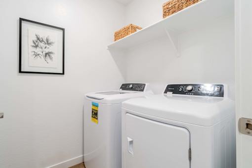 A small laundry room with a washer and dryer.