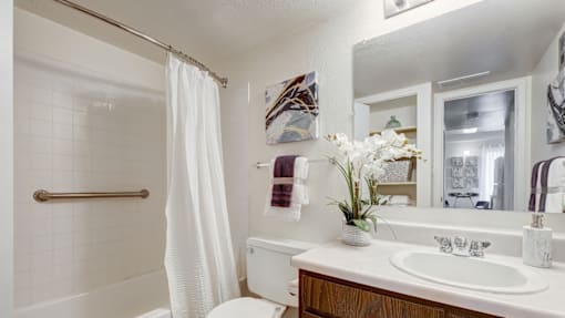 A white bathroom with a white tub, sink, and toilet.