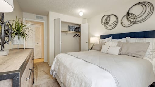 A bedroom with a large bed and a white wall.