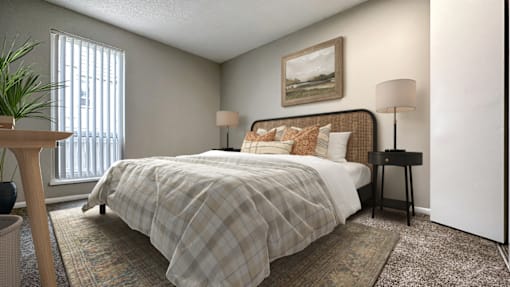 A bedroom with a bed, two lamps, and a painting on the wall.