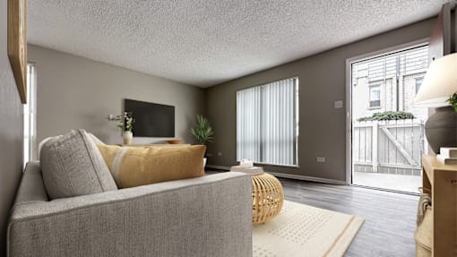 A living room with a grey couch and a yellow pillow.