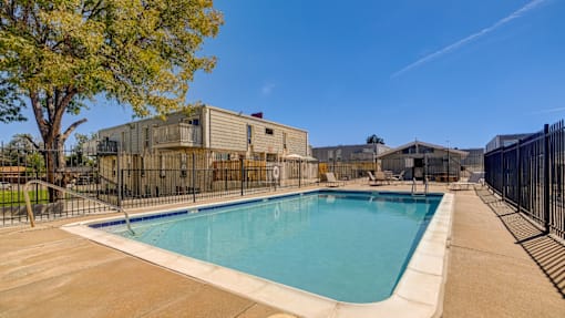 A large outdoor swimming pool surrounded by a fence.