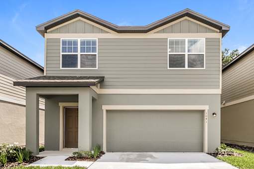 A modern house with a garage door and a brown door.