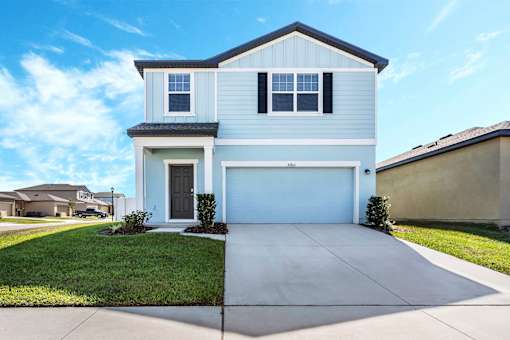 A two-story house with a garage and a driveway.