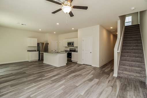 A spacious kitchen with a staircase leading to the upper floor.