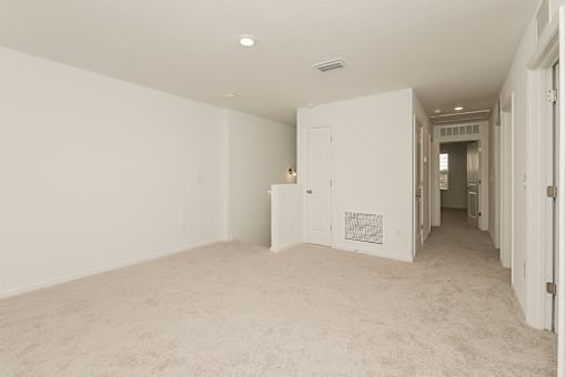 A room with white walls and carpeted floor.