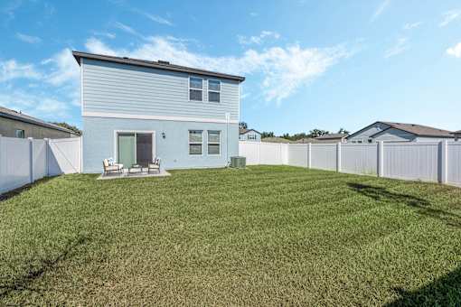 A house with a white fence and a green lawn.