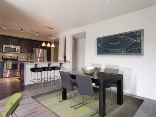 South Kirkland, WA Apartments for Rent - Kirkland Crossing - Dining Area with Pergo-Inspired Flooring, Table, Chairs, and View of Kitchen.