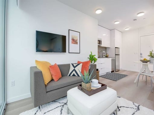 Apartments for Rent in Fremont, WA - Inspire Fremont - Living Room with Wood-Style Floors, Natural Lighting, and a White Ottoman