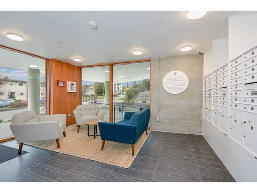 Apartments in Seattle, WA - Inspire Fremont - Lobby with Mail Slots, Floor-to-Ceiling Windows, and a Seating Area