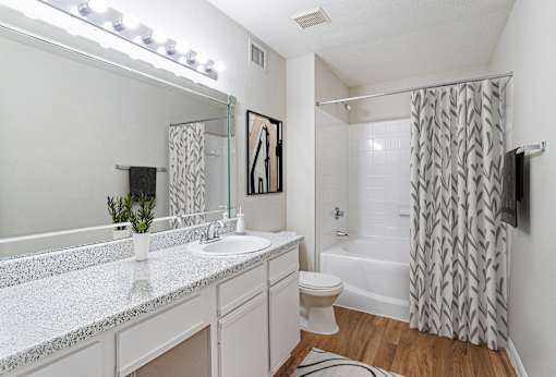 A bathroom with a white sink and a white toilet.