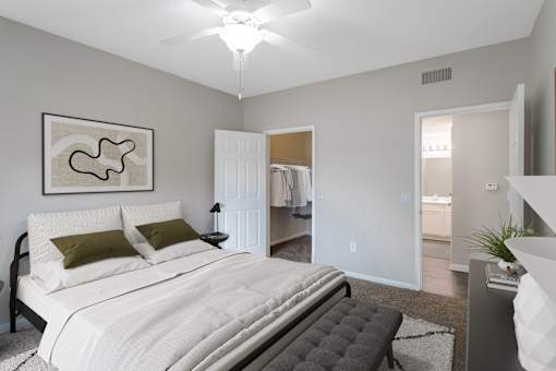 A bedroom with a large bed and a painting on the wall.