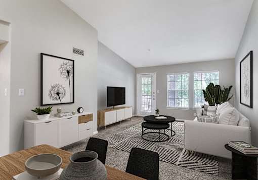 A modern living room with a dining table set for two.