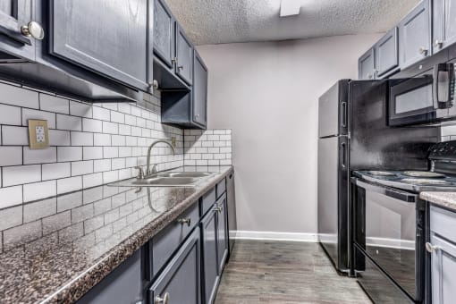 Whitney Manor Apartments in Gretna, LA photo of kitchen with subway tile back splash and hardwood floors
