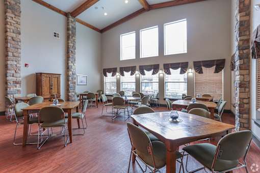A room with wooden floors and tables with chairs.