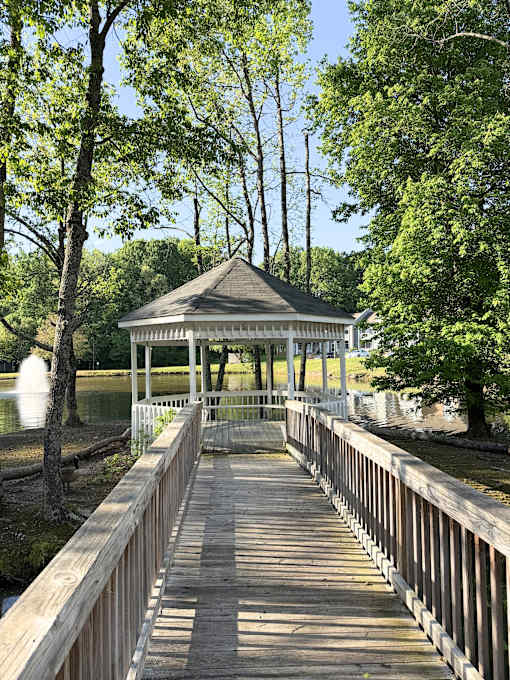 A gazebo sits on a wooden pier over a body of water.