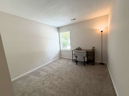 A room with a desk and chair in it.