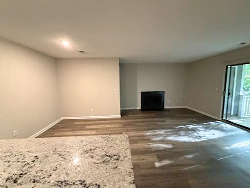 A room with a fireplace and a rug on the floor.