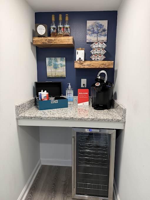 A kitchen with a wine cooler and a black kettle on the counter.