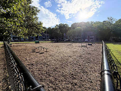 A playground with a metal fence and a dirt ground.
