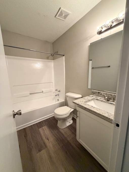A small bathroom with a toilet, sink, and bathtub.
