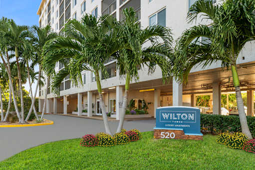 Exterior view of Wilton Tower apartments with palm trees in Wilton Manors, FL.