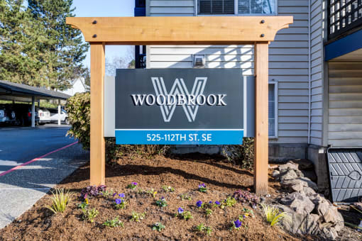 a wooden sign in front of a house