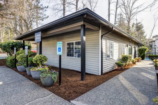 a small white building with a parking lot in front of it