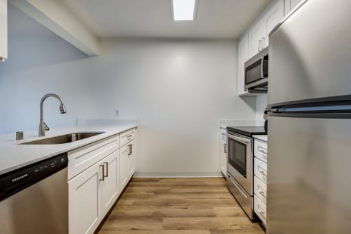 Apartments in Everett for Rent - Woodbrook - Kitchen with Wood-Style Flooring, White Countertops, White Cabinets, and Stainless Steel Appliances