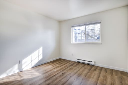 Apartments for Rent in Everett Washington - Woodbrook - Empty Bedroom with Wood-Style Flooring and Window