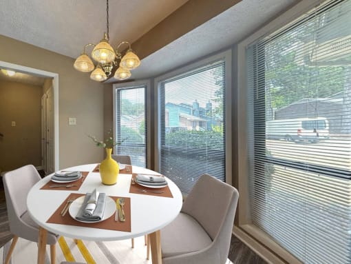 a dining room with a table and chairs and large windows