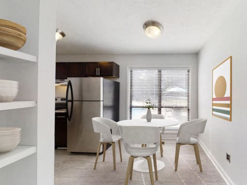 a dining room with a table and chairs and a stainless steel refrigerator