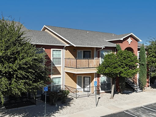 A two-story apartment building with a balcony on the second floor.