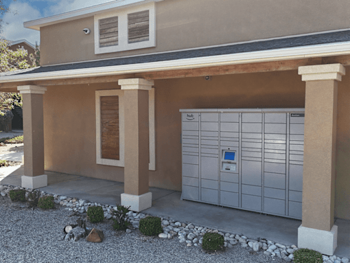 A house with a brown and beige exterior and a grey garage door.