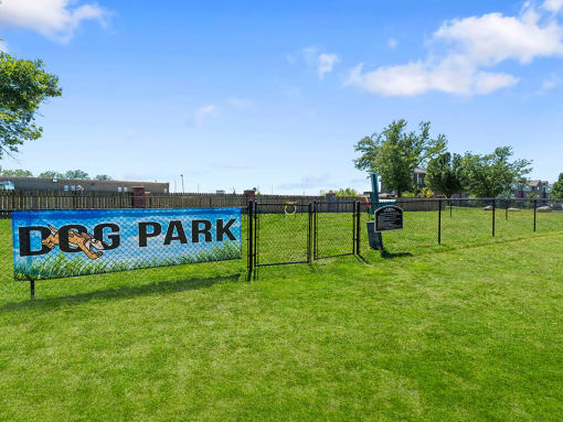 a sign that says dog park on the side of a fence