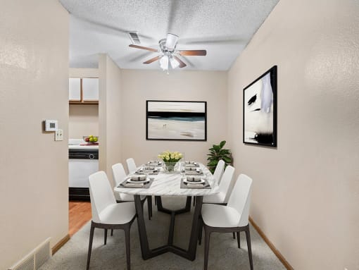 a dining room with a table and chairs and a ceiling fan