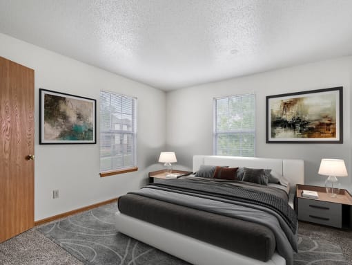 a bedroom with a bed and two windows