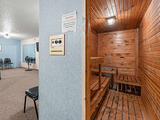 A room with a wooden sauna and a sign on the wall.
