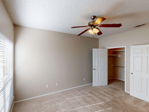 a bedroom with a ceiling fan and closet
