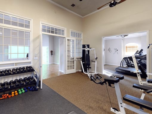 an apartment gym with a treadmill and weights