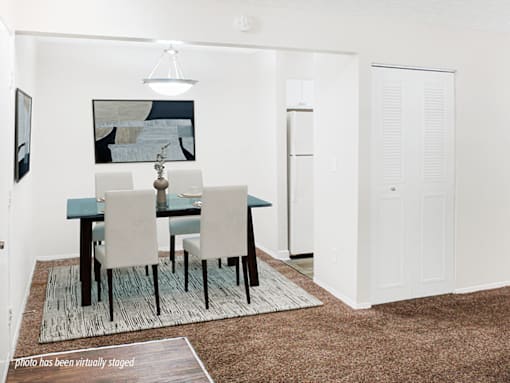 A dining room with a table and chairs.