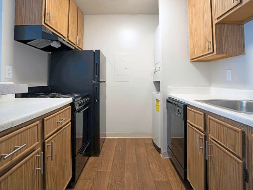 a kitchen with wooden cabinets and a black refrigerator