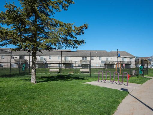 a playground in a park in front of an apartment building