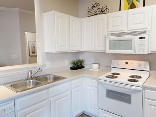 a kitchen with white Shaker cabinets and white appliances