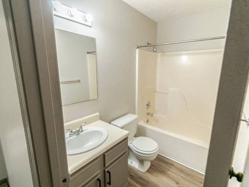 A bathroom with a toilet, sink, and bathtub.
