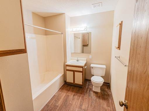 A small bathroom with a toilet, sink, and shower.