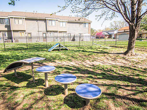A playground with a blue table and a slide in the background.