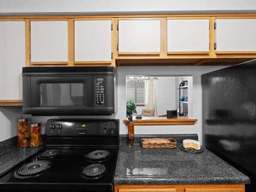 a kitchen with a black stove and a microwave