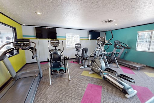 A gym with treadmills, elliptical machines, and exercise bikes.